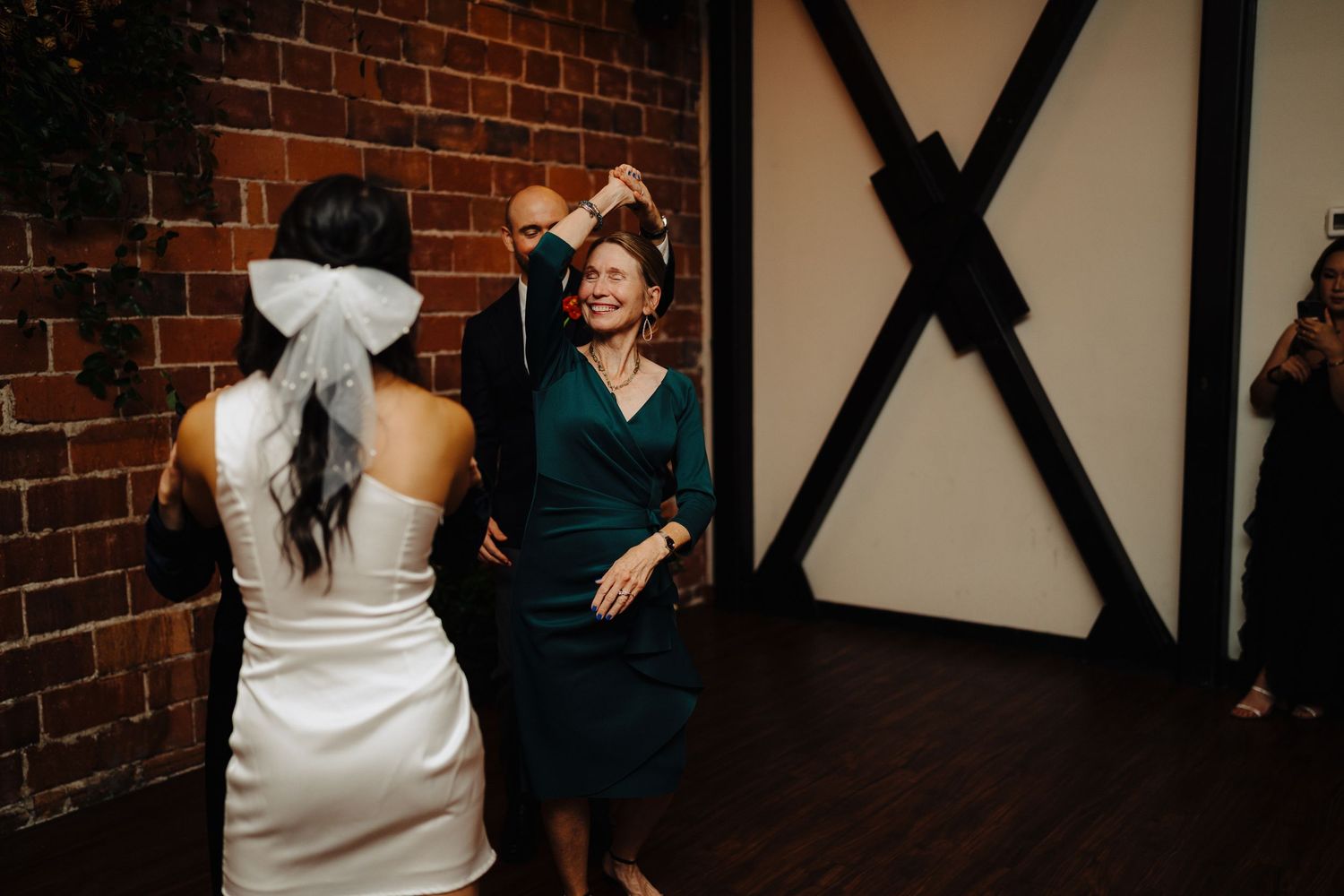 Wedding celebration scene with exposed brick wall and decorative black beams.