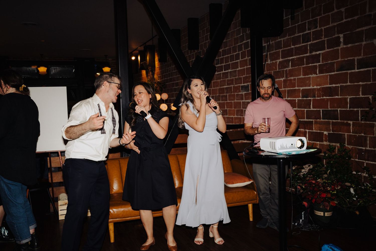 Wedding guests singing karaoke and having fun at the reception.