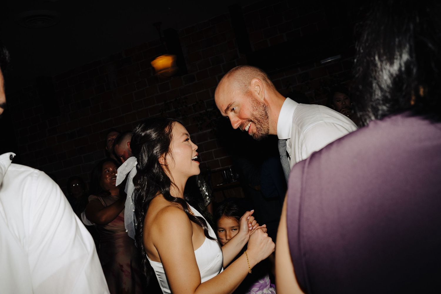 Wedding couple dancing and laughing together on dance floor.