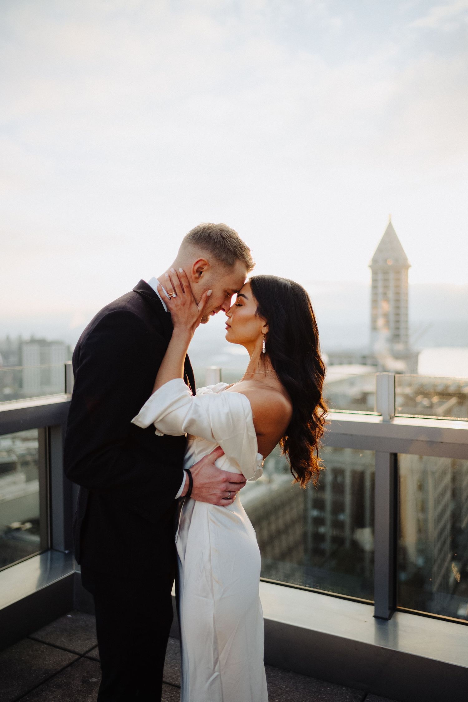 A couple sharing an intimate moment on a rooftop terrace with city views and historic architecture.