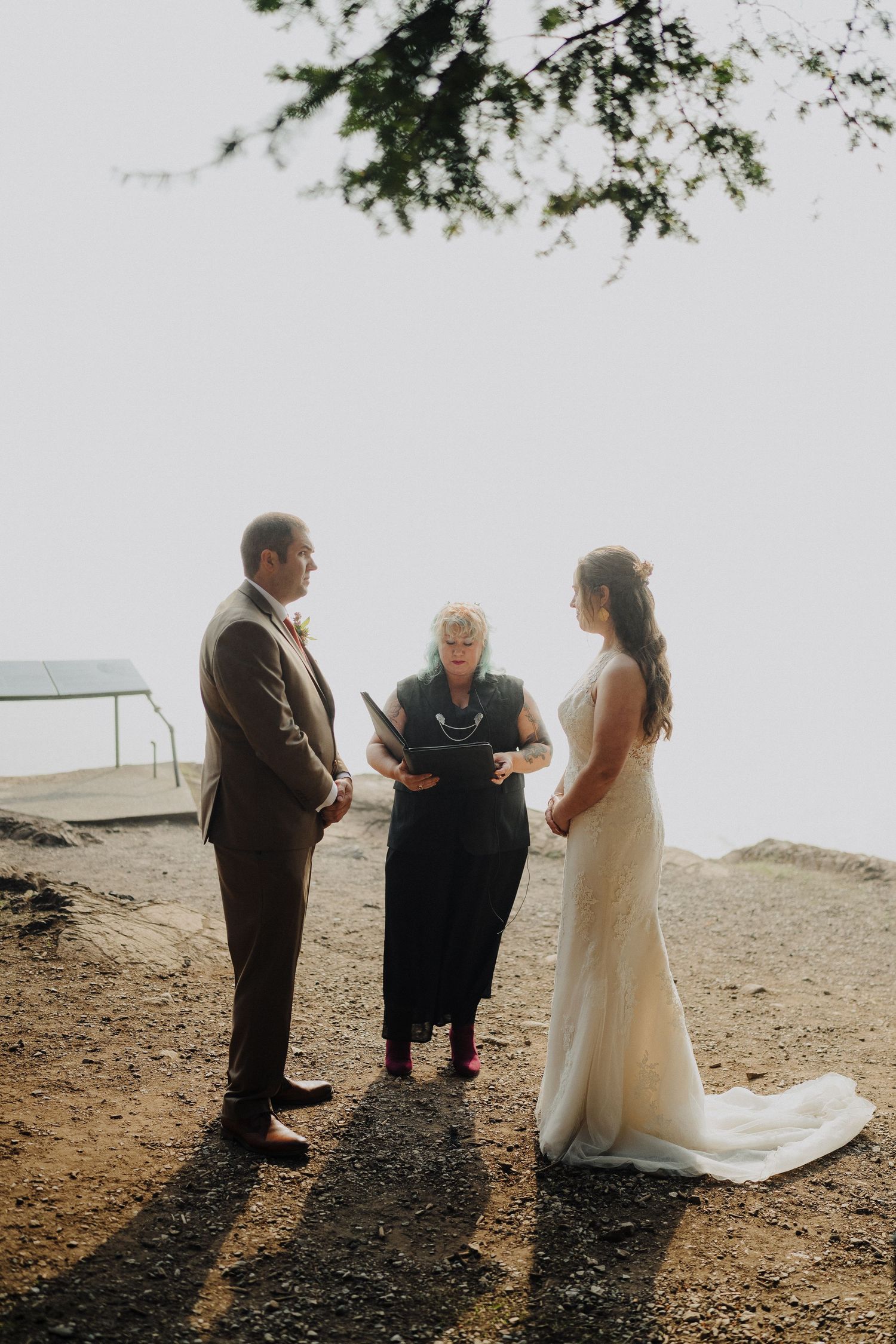 A intimate wedding ceremony takes place on a misty cliff overlooking the ocean.
