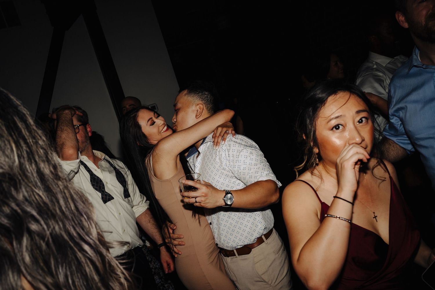 Energetic party scene with people dancing in a dark venue.