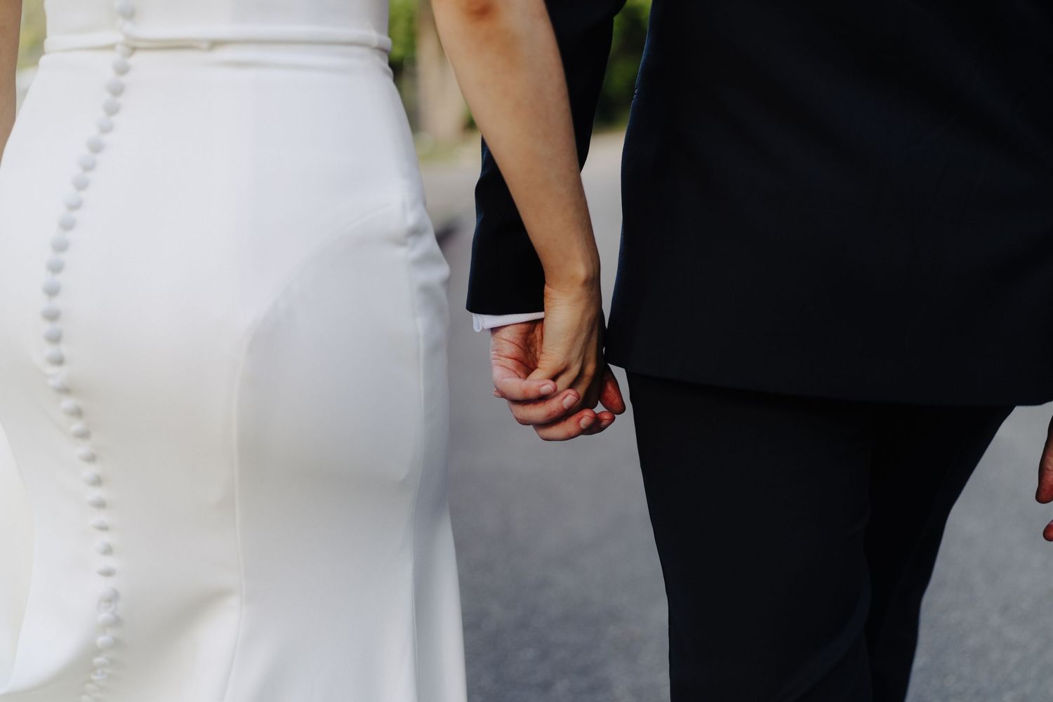 Back view of bride and groom walking together on their wedding day.