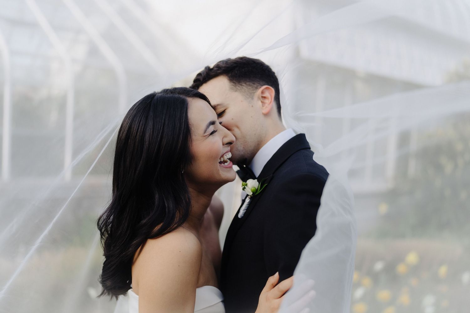 A romantic wedding moment captured through delicate bridal veil.