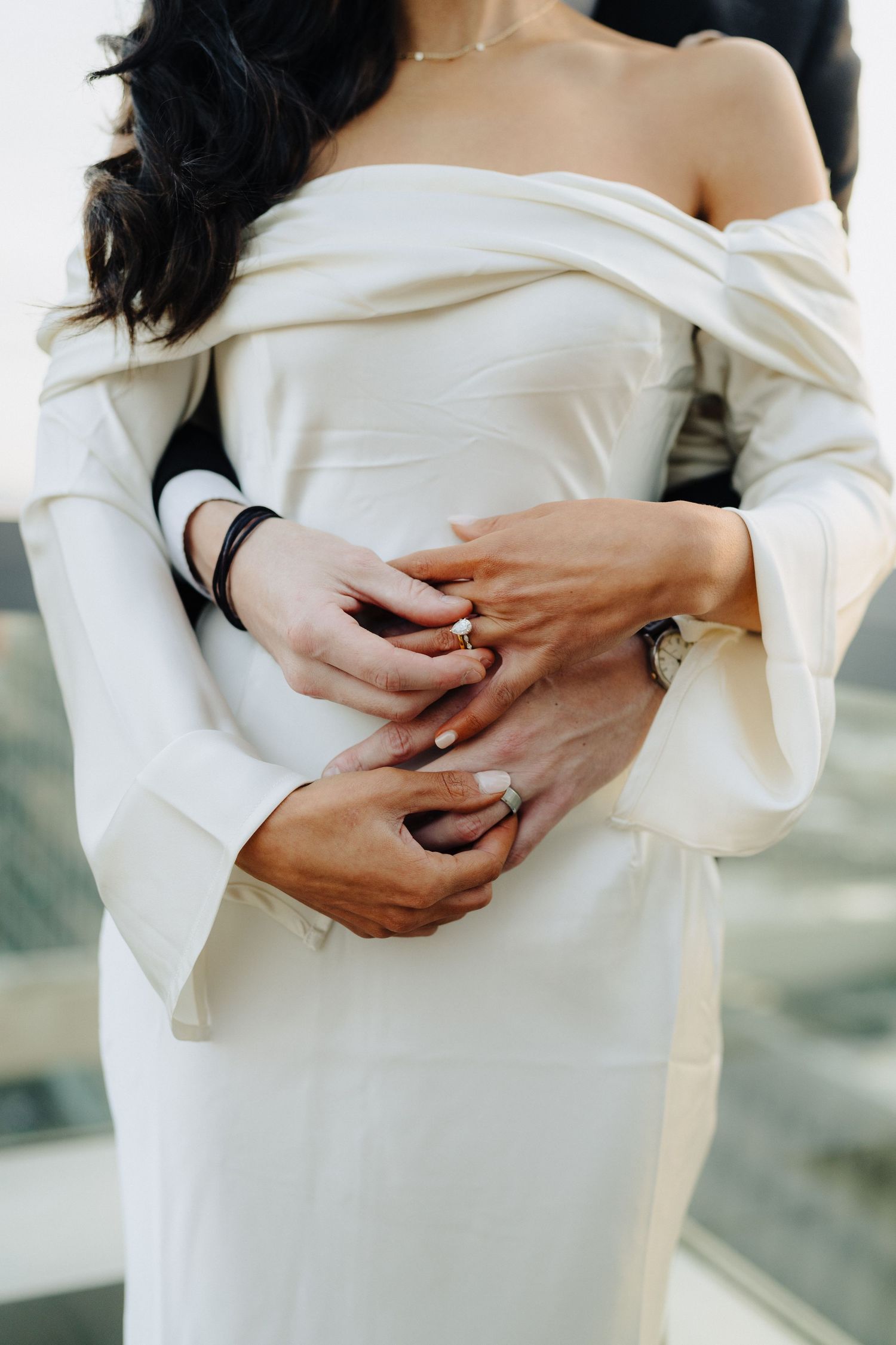 Close-up of an elegant off-shoulder white wedding dress with bell sleeves and delicate hand details.