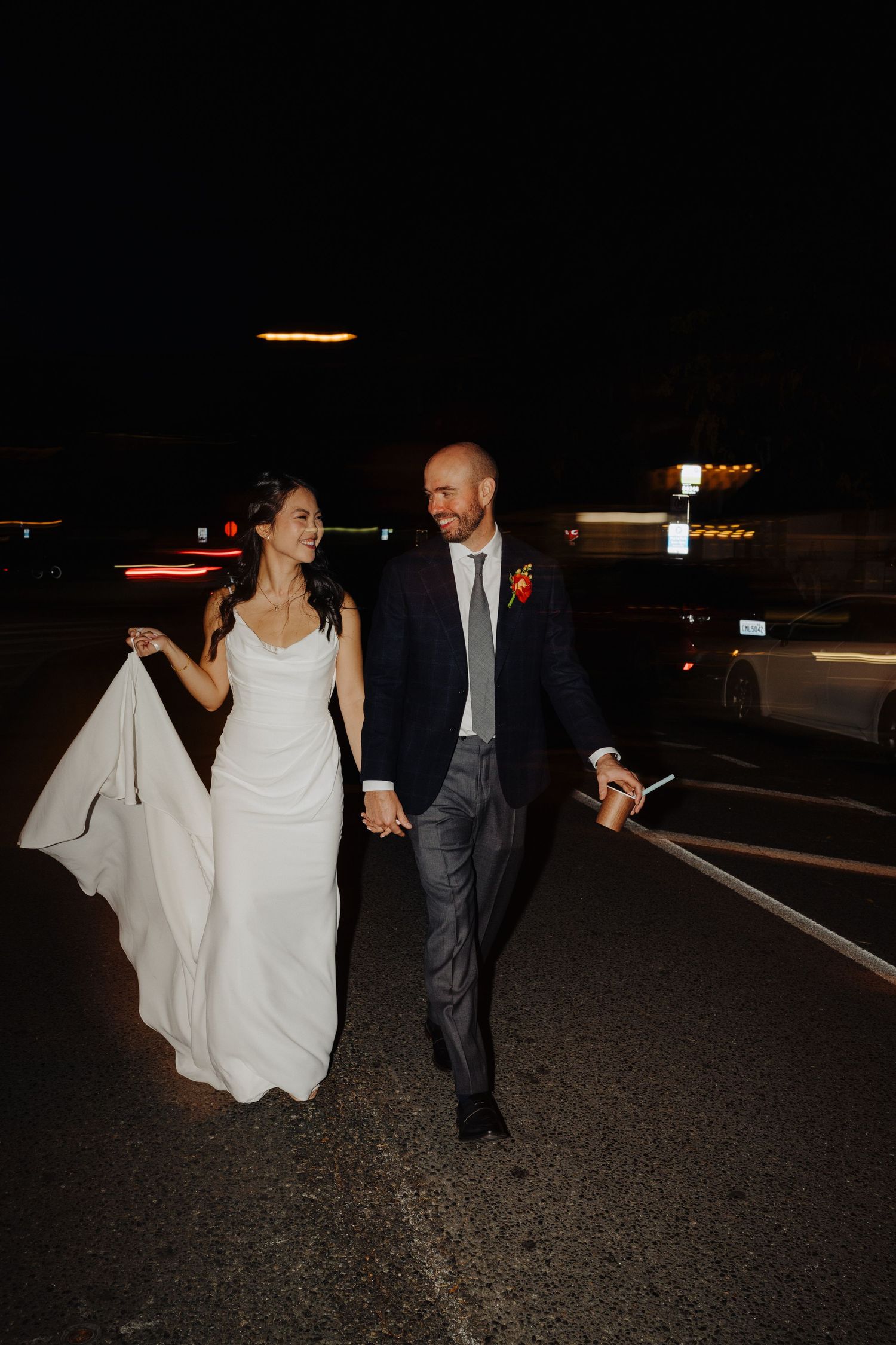 Couple walking together at night after their wedding celebration.
