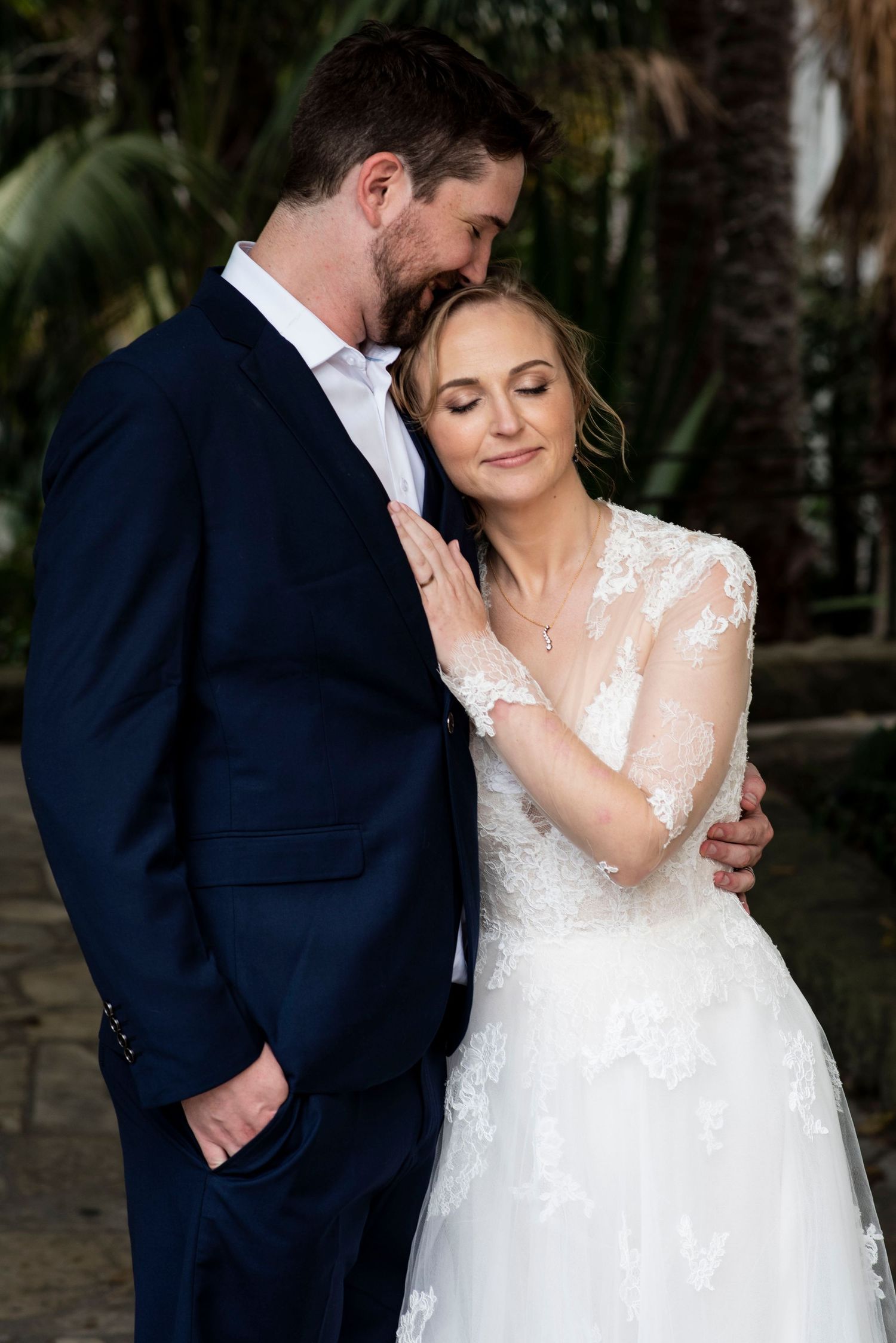 Bride and groom share a quiet, intimate moment on their wedding day in Santa Barbara, California, surrounded by lush greenery and palm trees