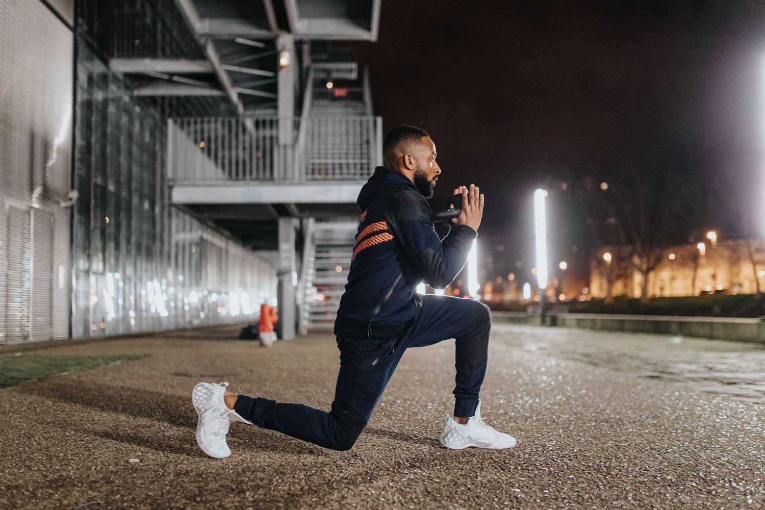 Six sequential frames of a person performing a lunge exercise on concrete ground at night under artificial lighting.