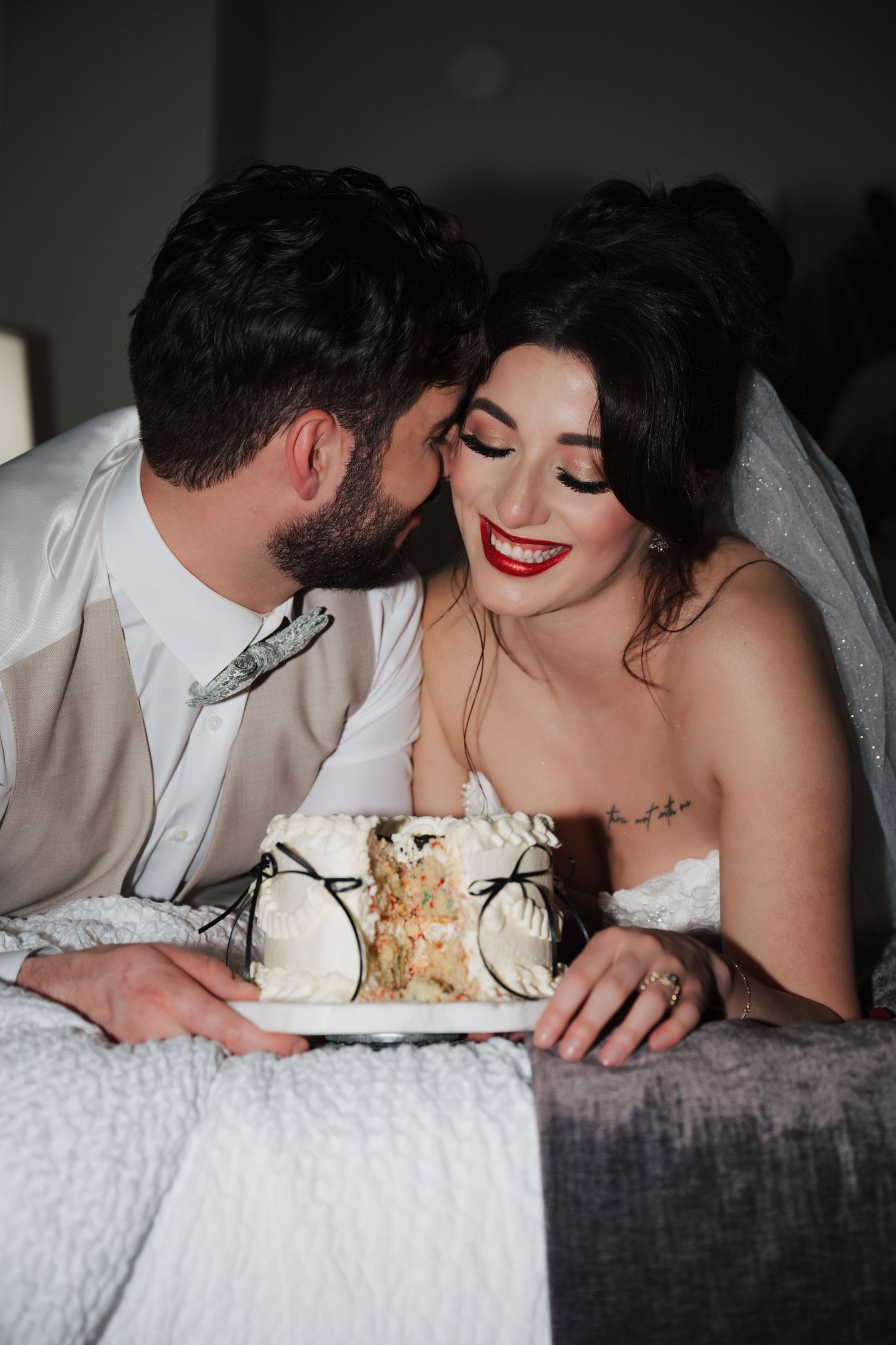 Intimate wedding moment shared over a slice of white cake with delicate decorations.