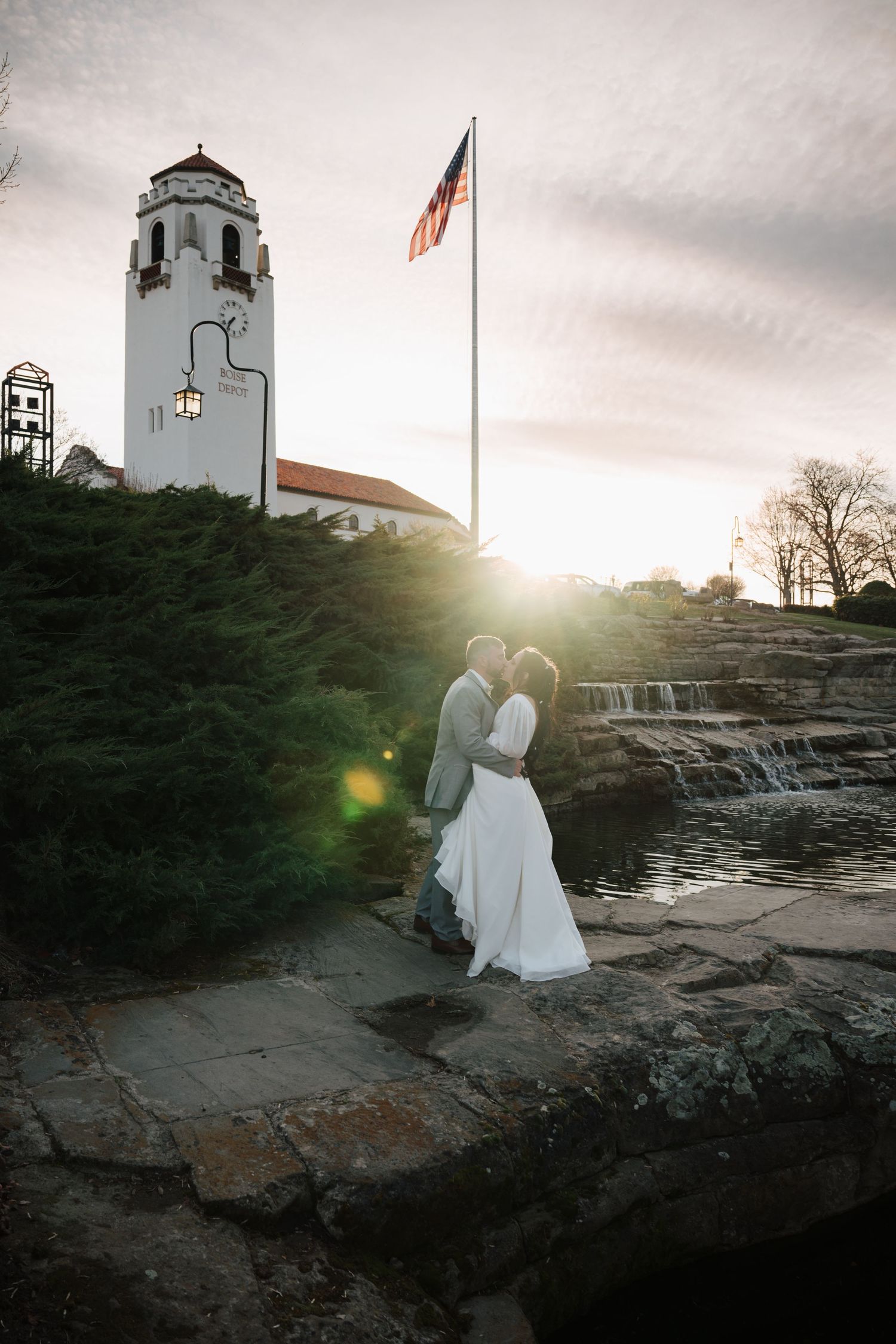 A romantic sunset silhouette at Boise Depot with an American flag and historic bell tower in the background.