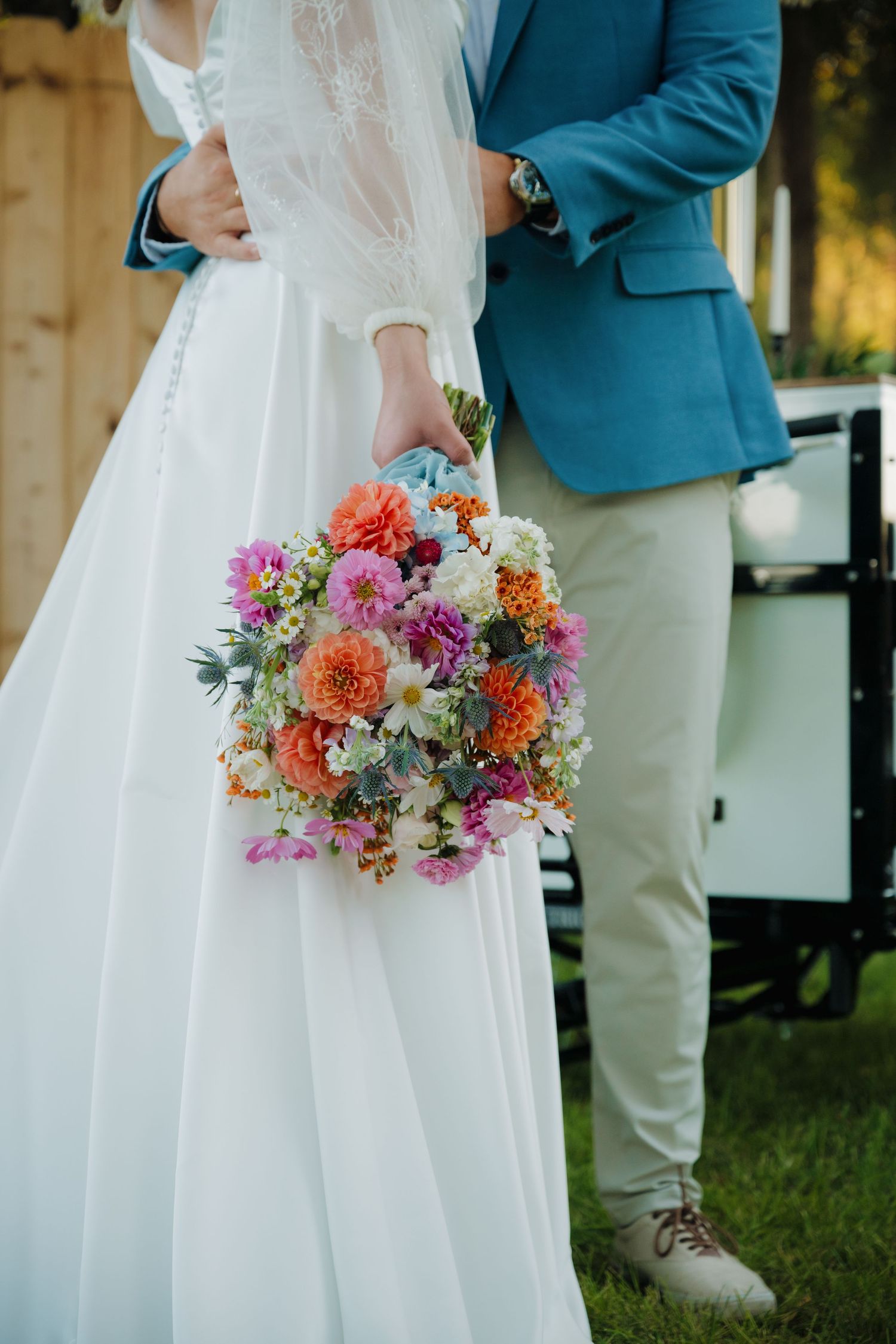 Close-up of vibrant multicolored bridal bouquet with coral, pink and white flowers.