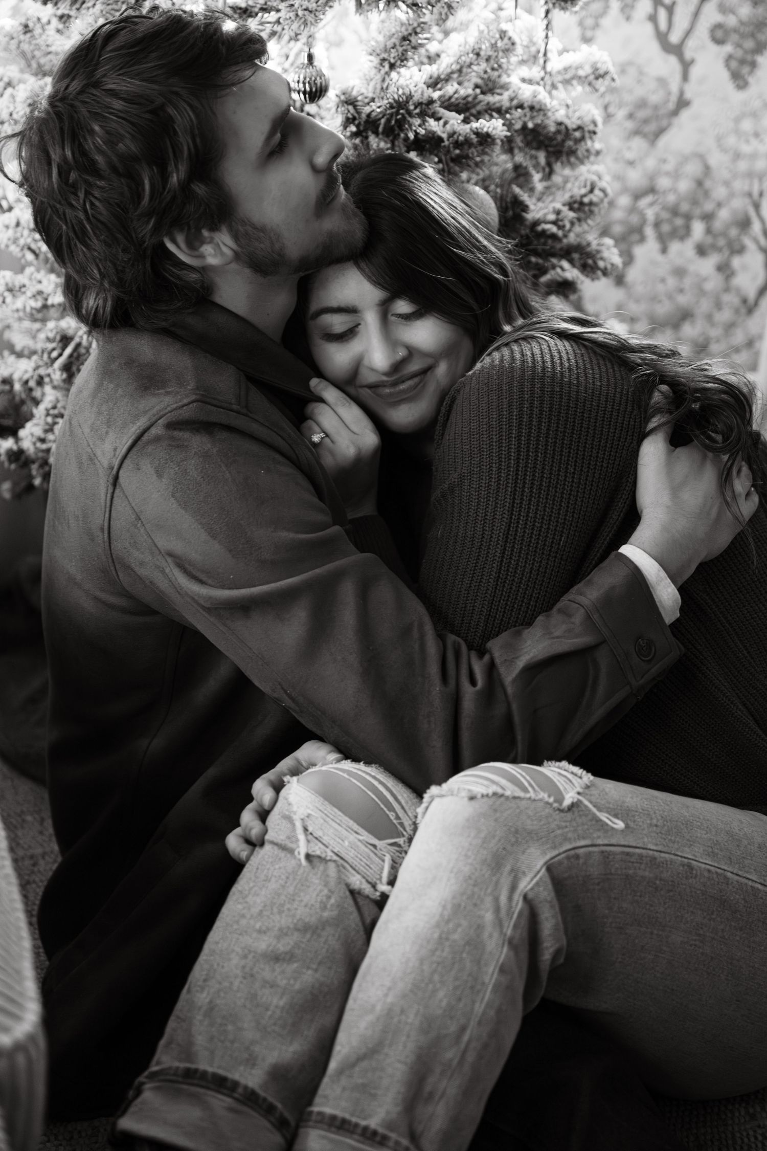 A tender black and white portrait of a couple sharing an intimate embrace outdoors.