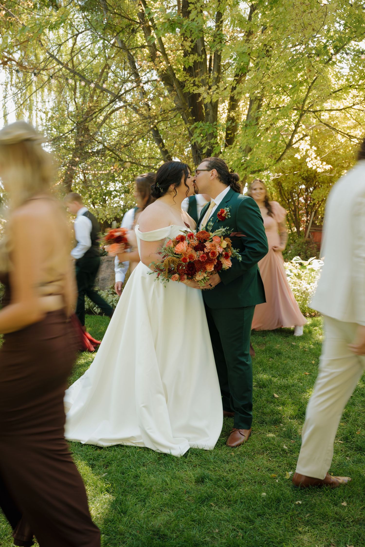 A couple shares a moment during their garden wedding reception surrounded by guests.