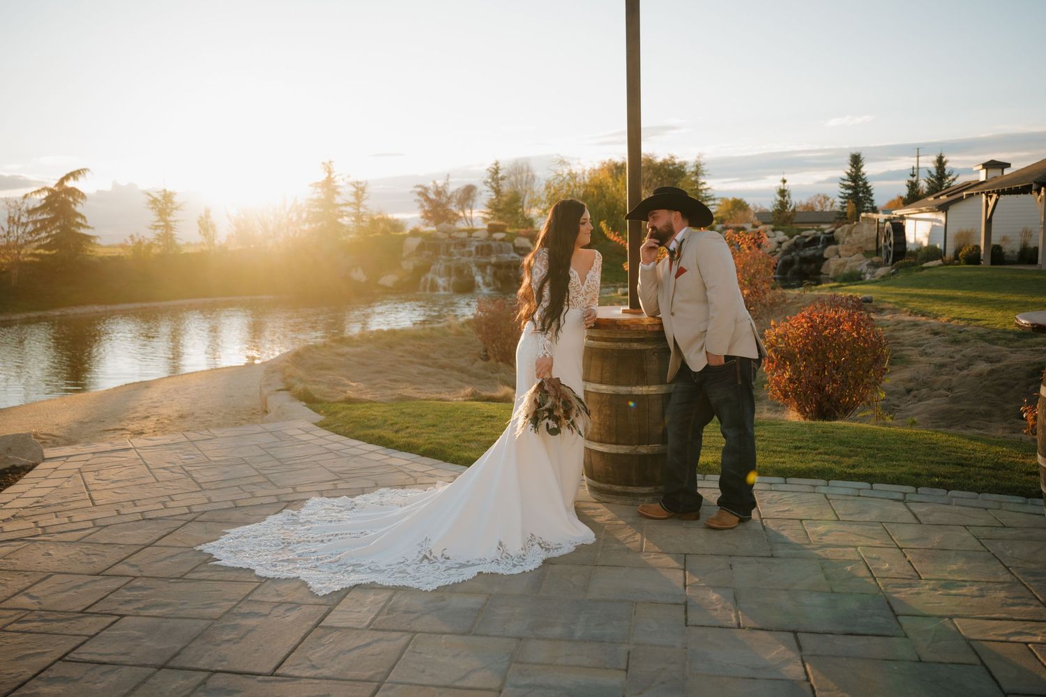 Sunset wedding portrait by lakeside with golden hour lighting and mountain backdrop.