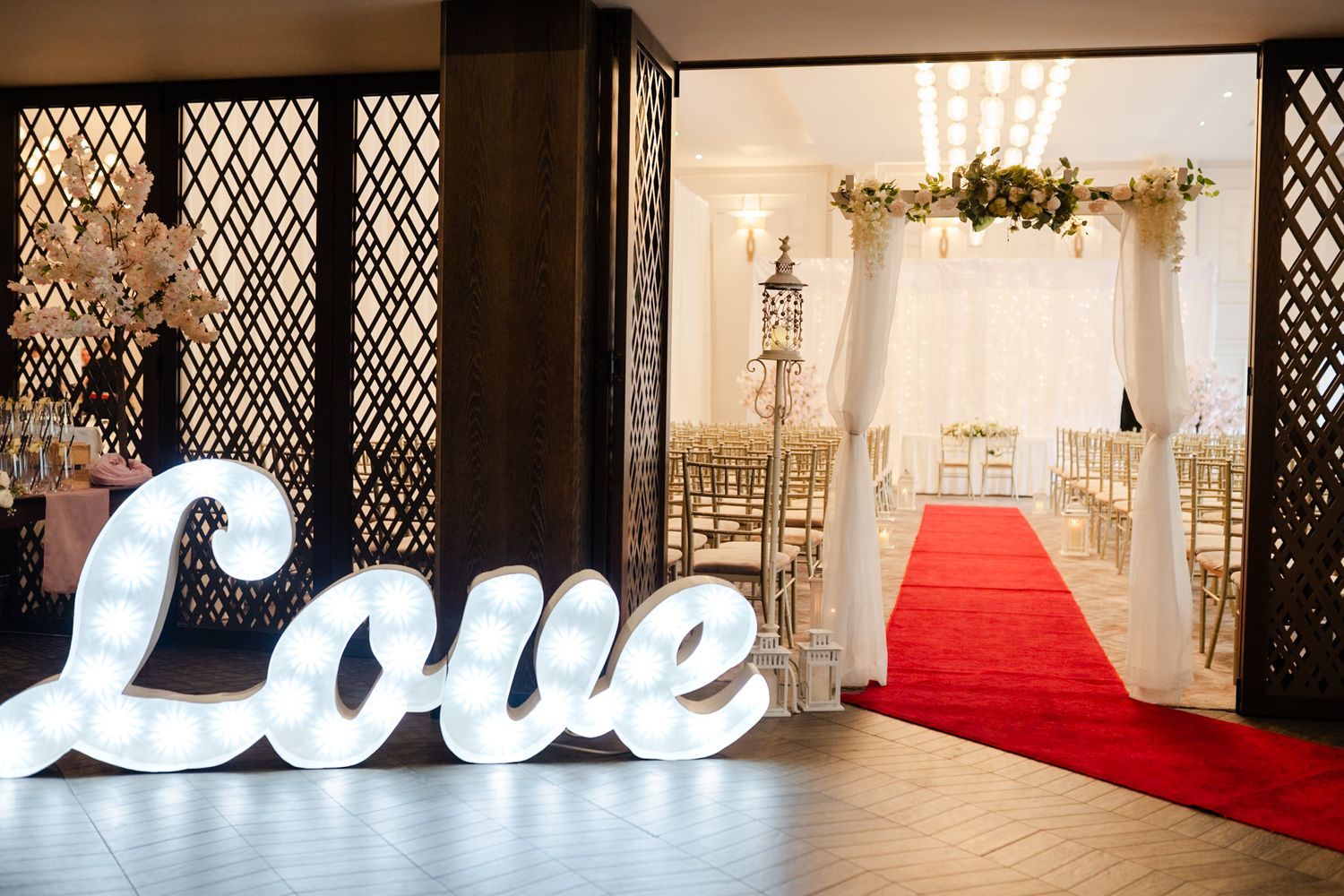 Elegant wedding venue collage featuring crystal chandeliers, romantic white decor, red carpets and illuminated love sign.