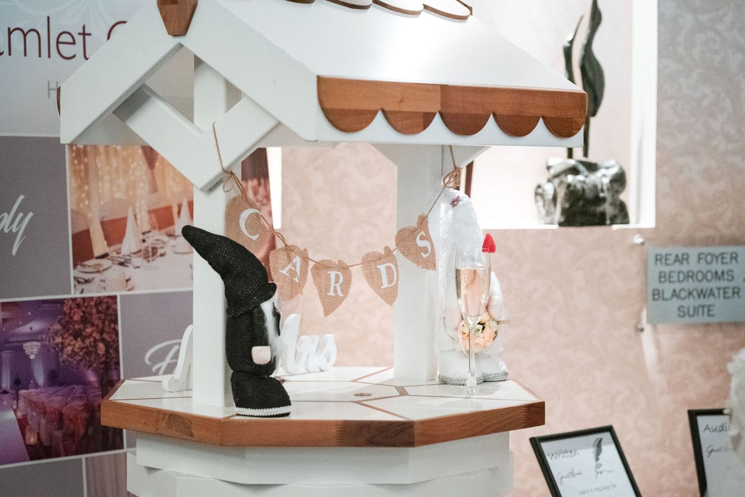 Romantic wedding venue decorations with pink and white decor and floral arrangements displayed on shelving.