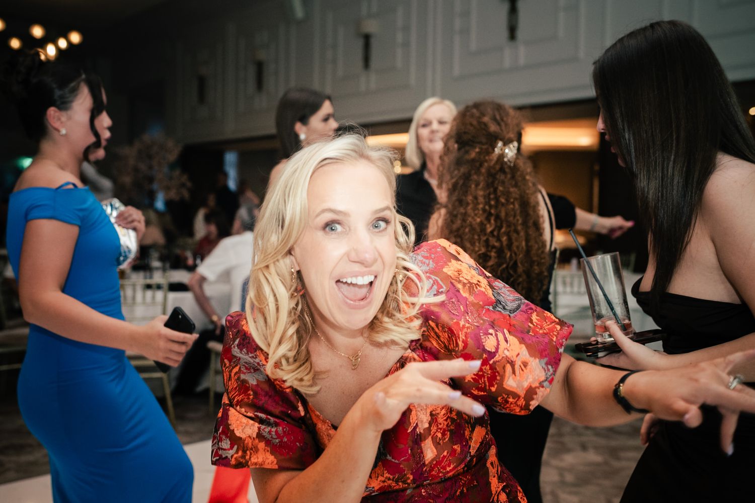 Guests dancing and celebrating at a lively wedding reception with festive energy and soft lighting.
