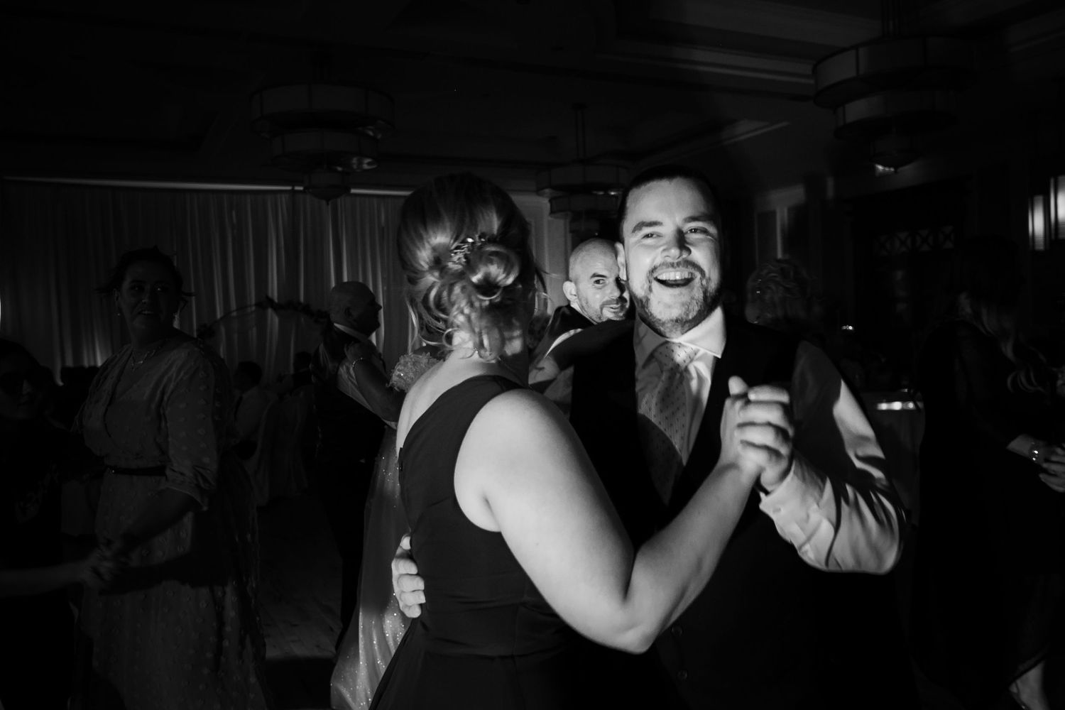 Two people share an elegant dance together at an evening reception in black and white.