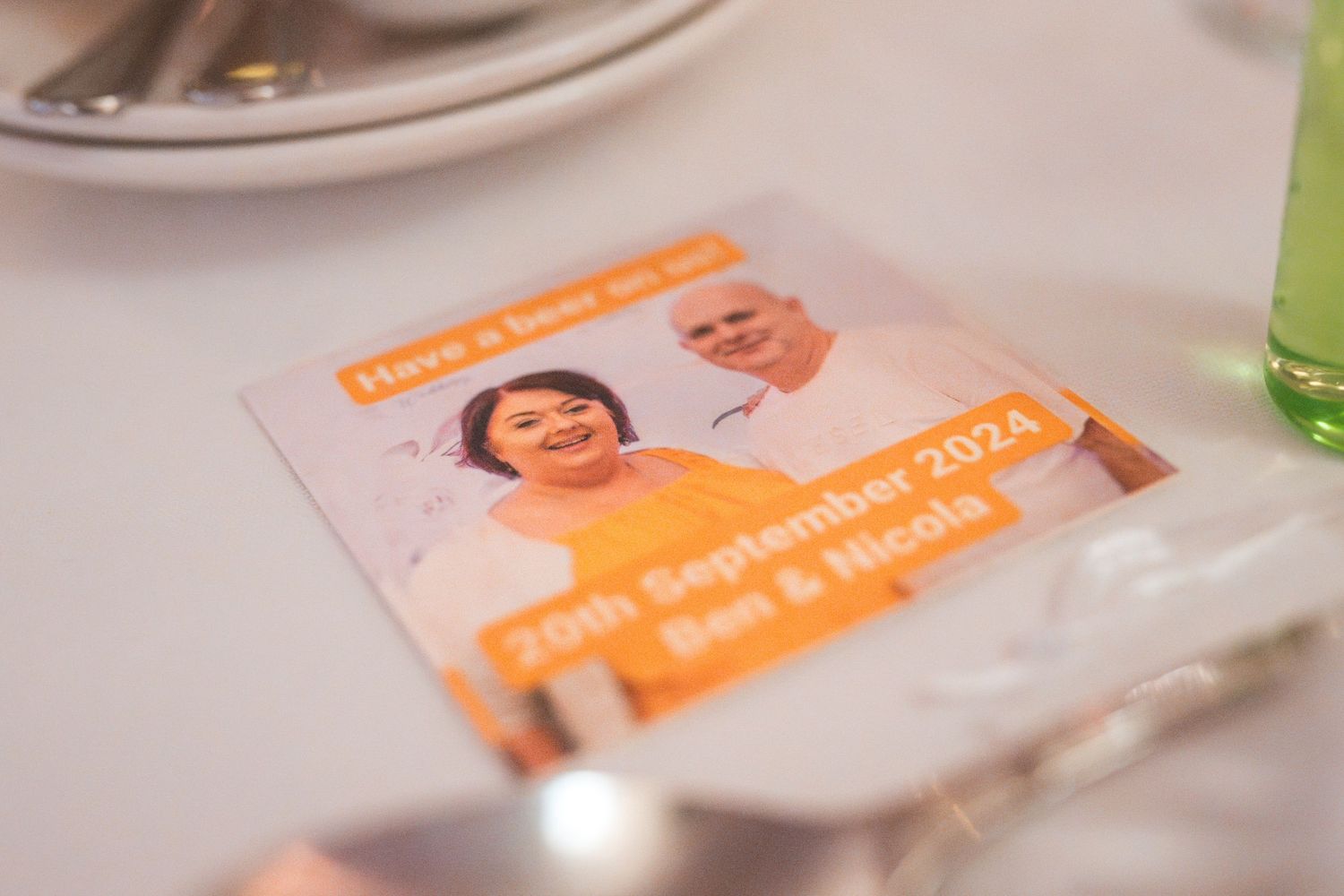 Wedding welcome cards and name tags arranged on a light colored surface.