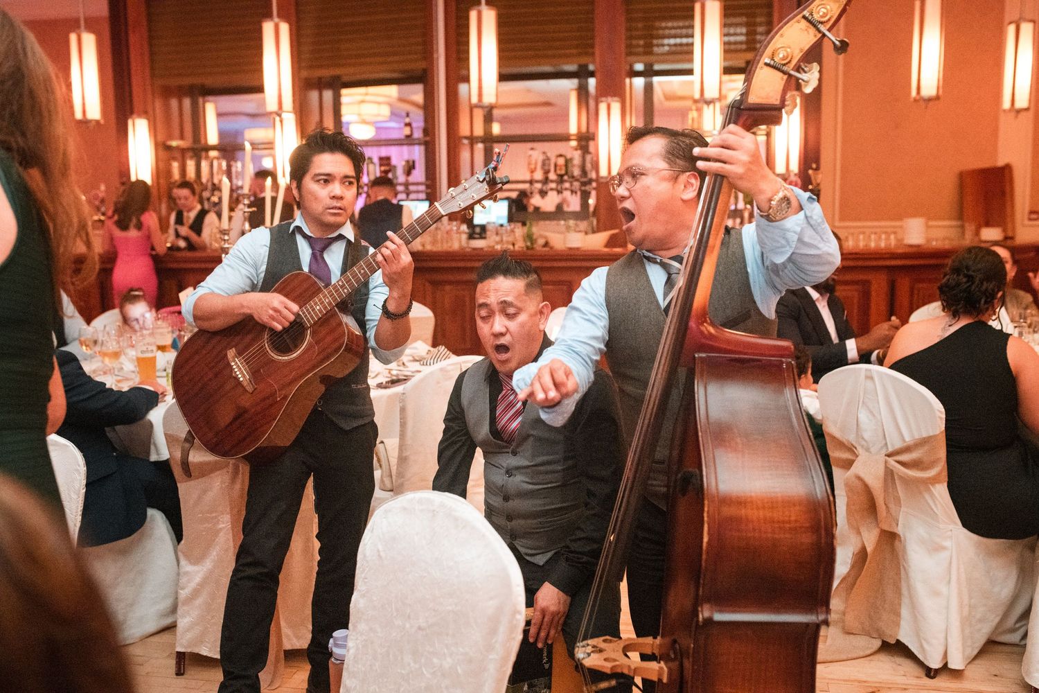 Couples dancing together at an elegant evening reception in a warmly lit ballroom.