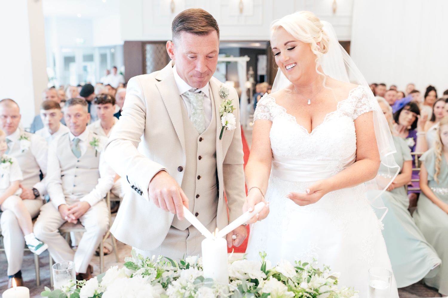 A bride and groom in light-colored attire share a moment together during their wedding ceremony.