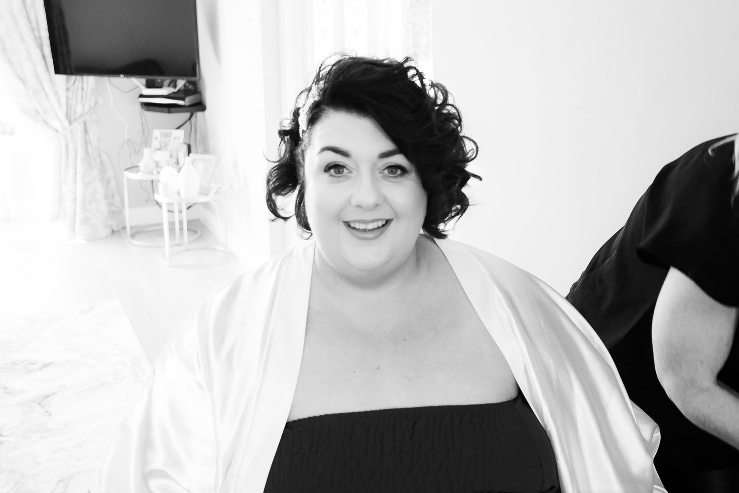 Black and white portrait of a person in formal attire with curled dark hair styled in an elegant updo.