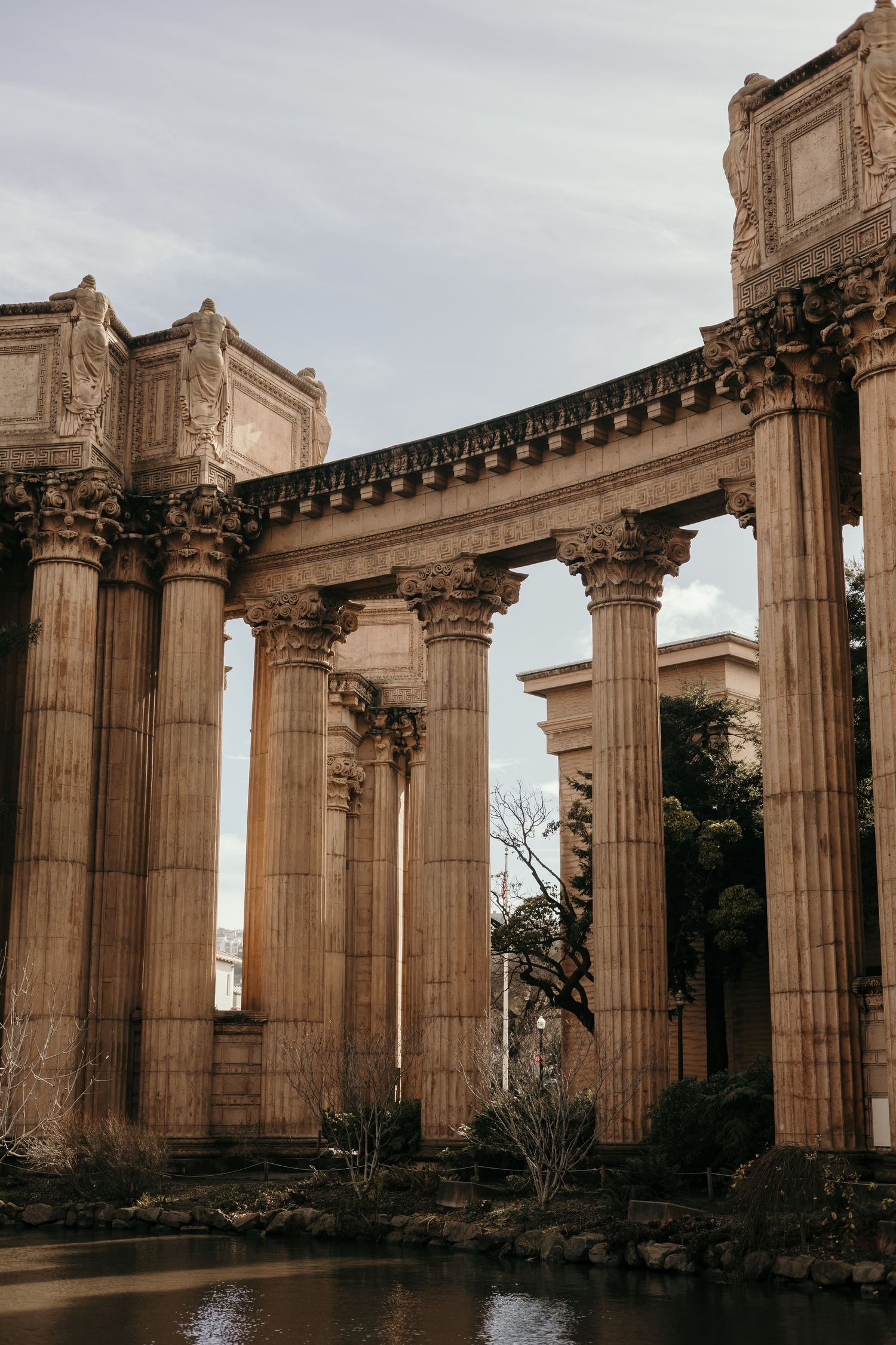 Classical stone columns of the Palace of Fine Arts reflecting in the lagoon.