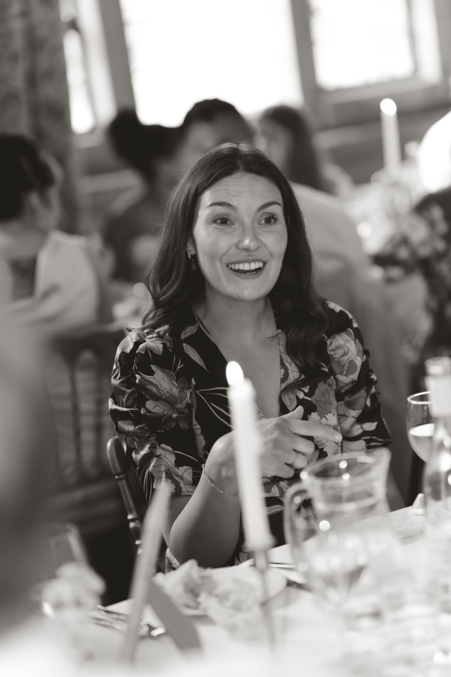 A guest at a formal event dines at an elegantly decorated table set with glassware and floral centerpieces.