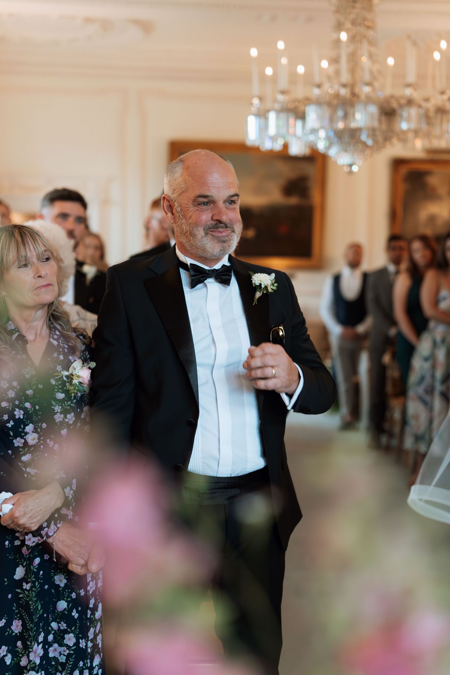 People in formal attire dancing and celebrating with joyous expressions at an elegant ballroom reception.