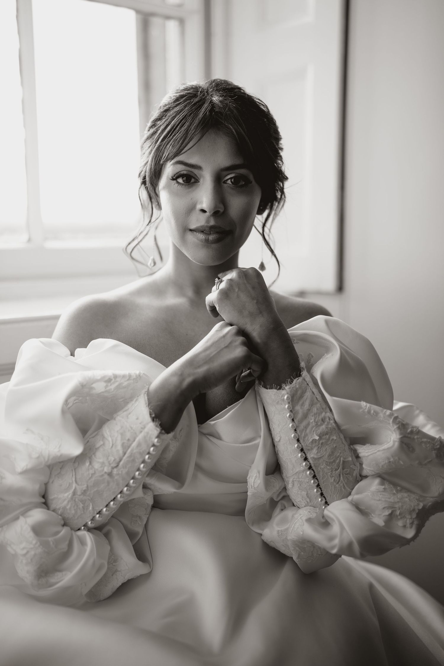 An elegant bridal portrait in black and white featuring a dress with dramatic puff sleeves.