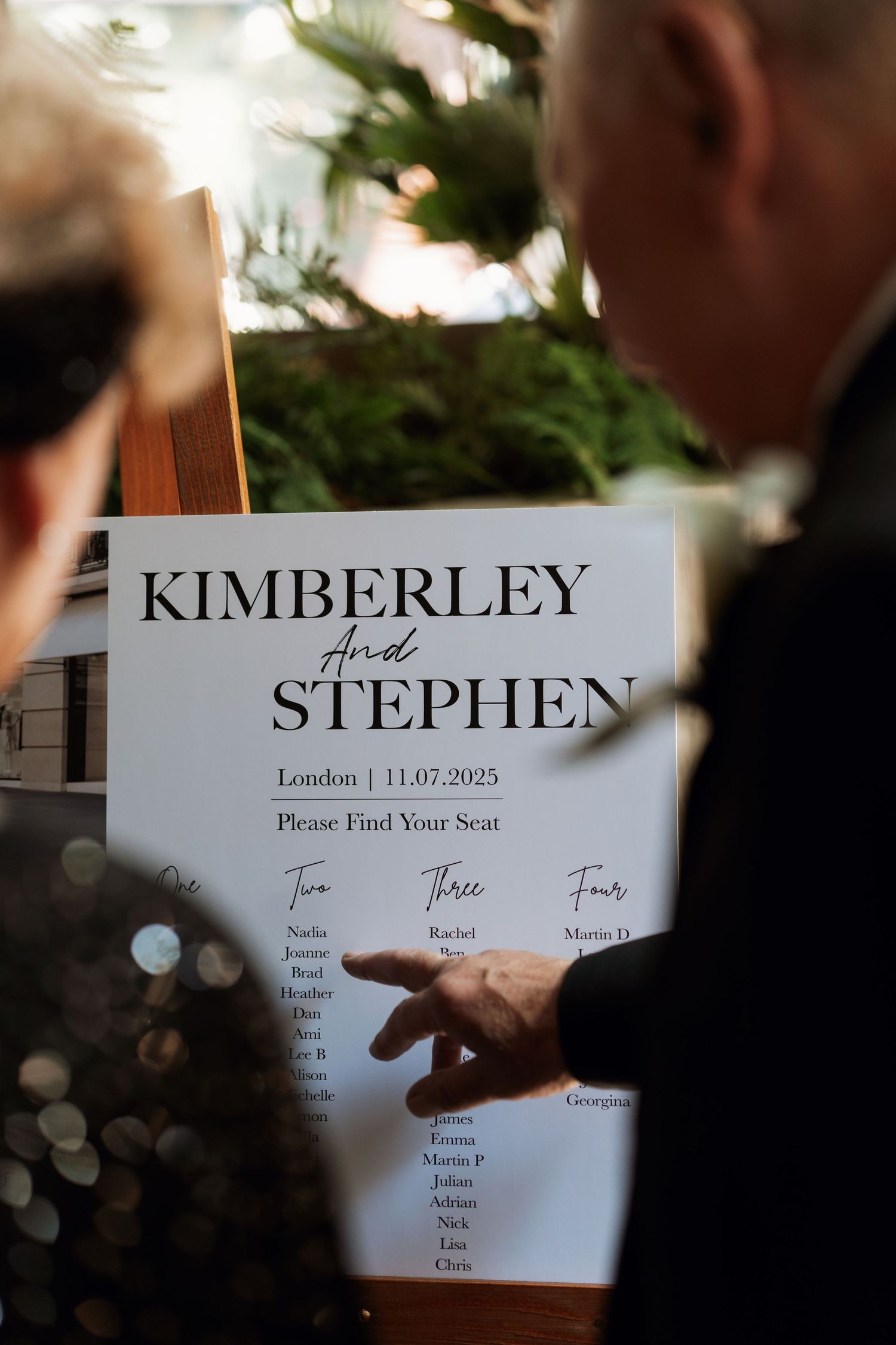 Wedding seating chart details being arranged with names displayed on elegant white cards.