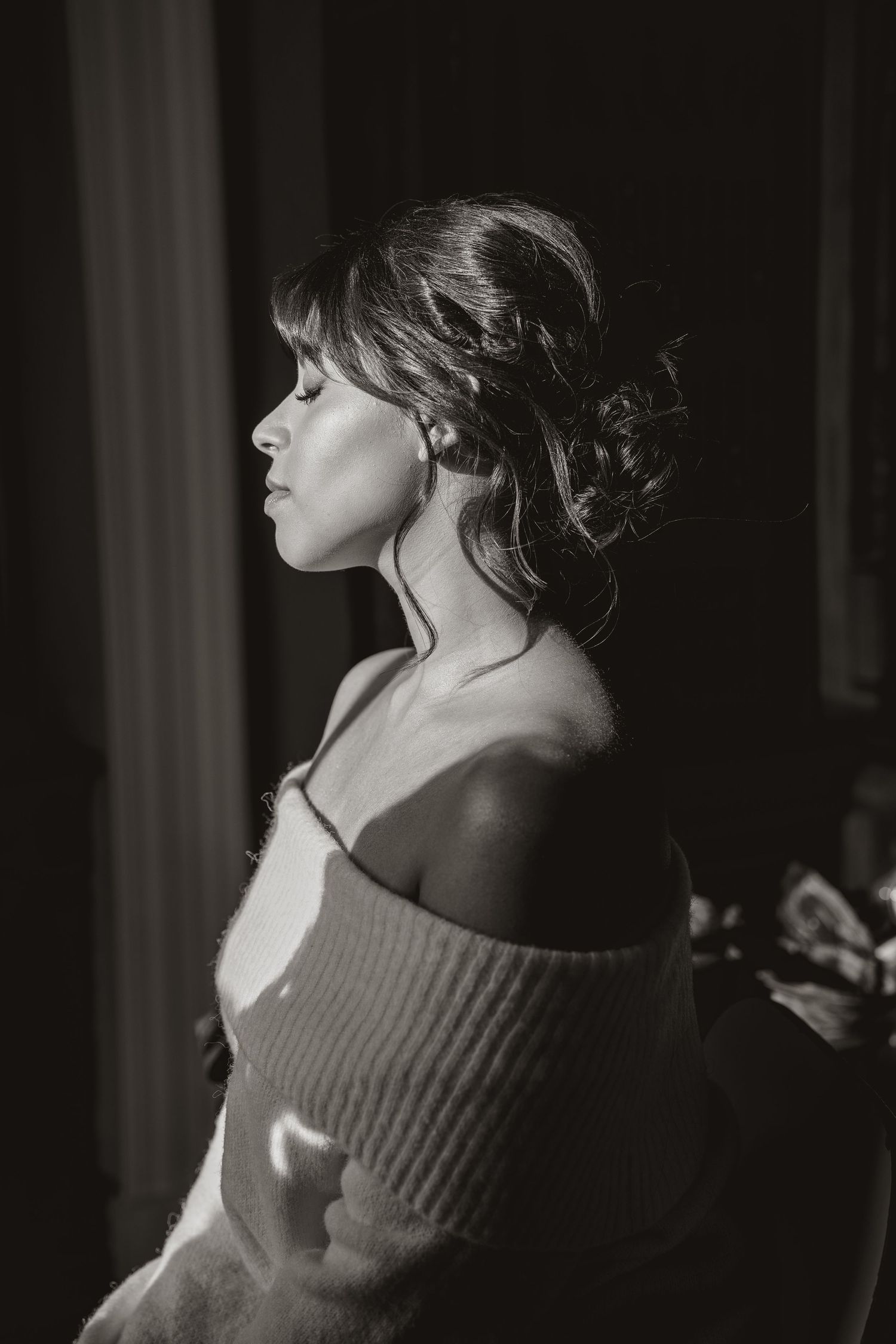 An artistic black and white portrait capturing a soft, romantic moment.