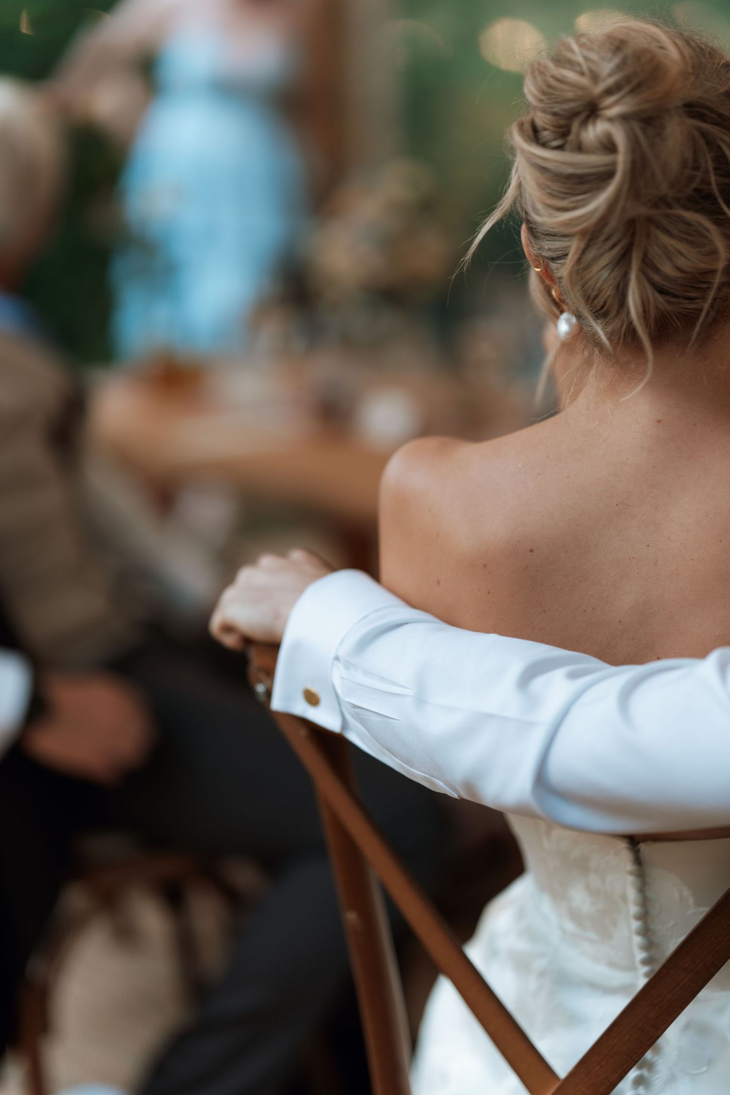 Detail shot of a bride's white wedding dress and hair from behind.