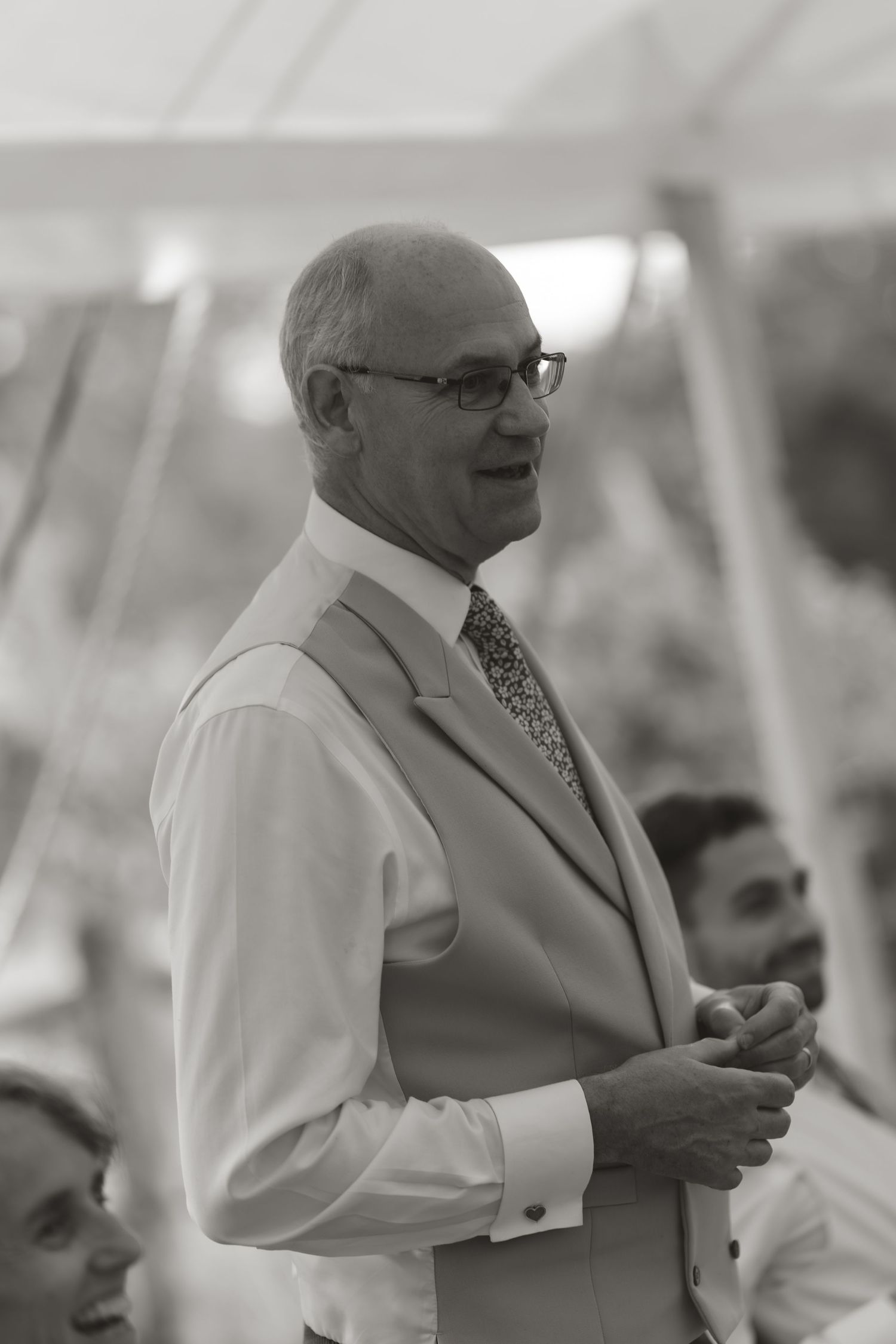 Person in formal attire speaking and gesturing during special event.
