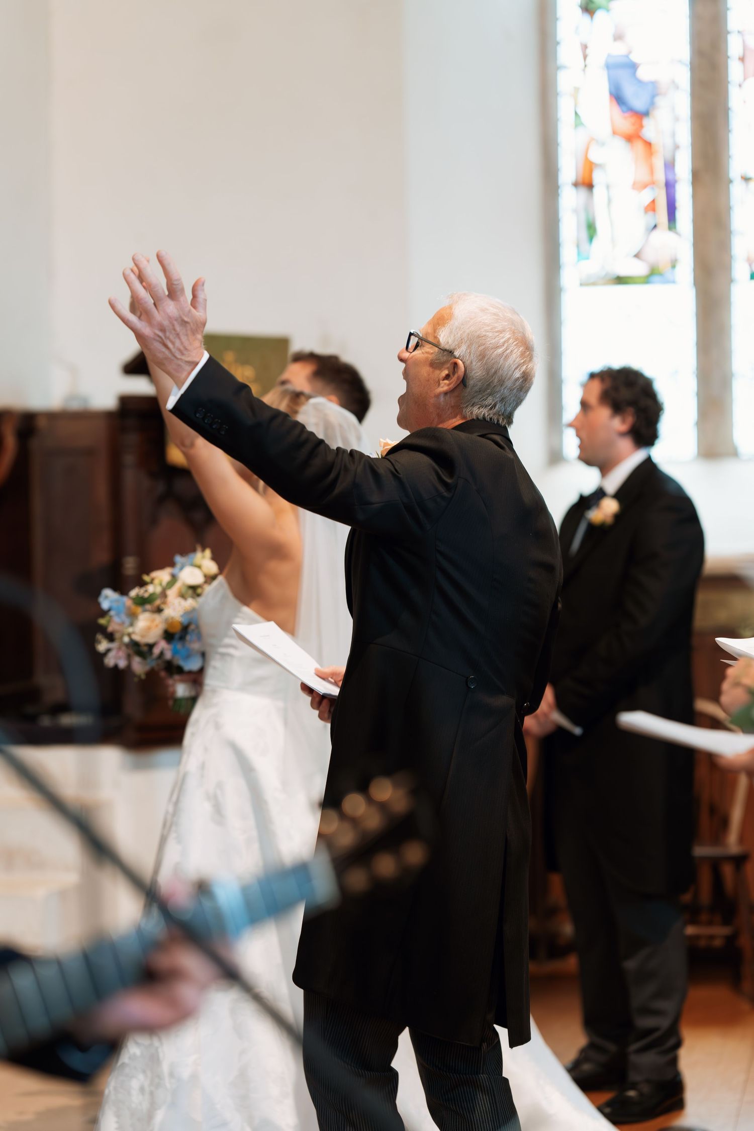 Wedding celebration scene with people raising their arms in joyful celebration.