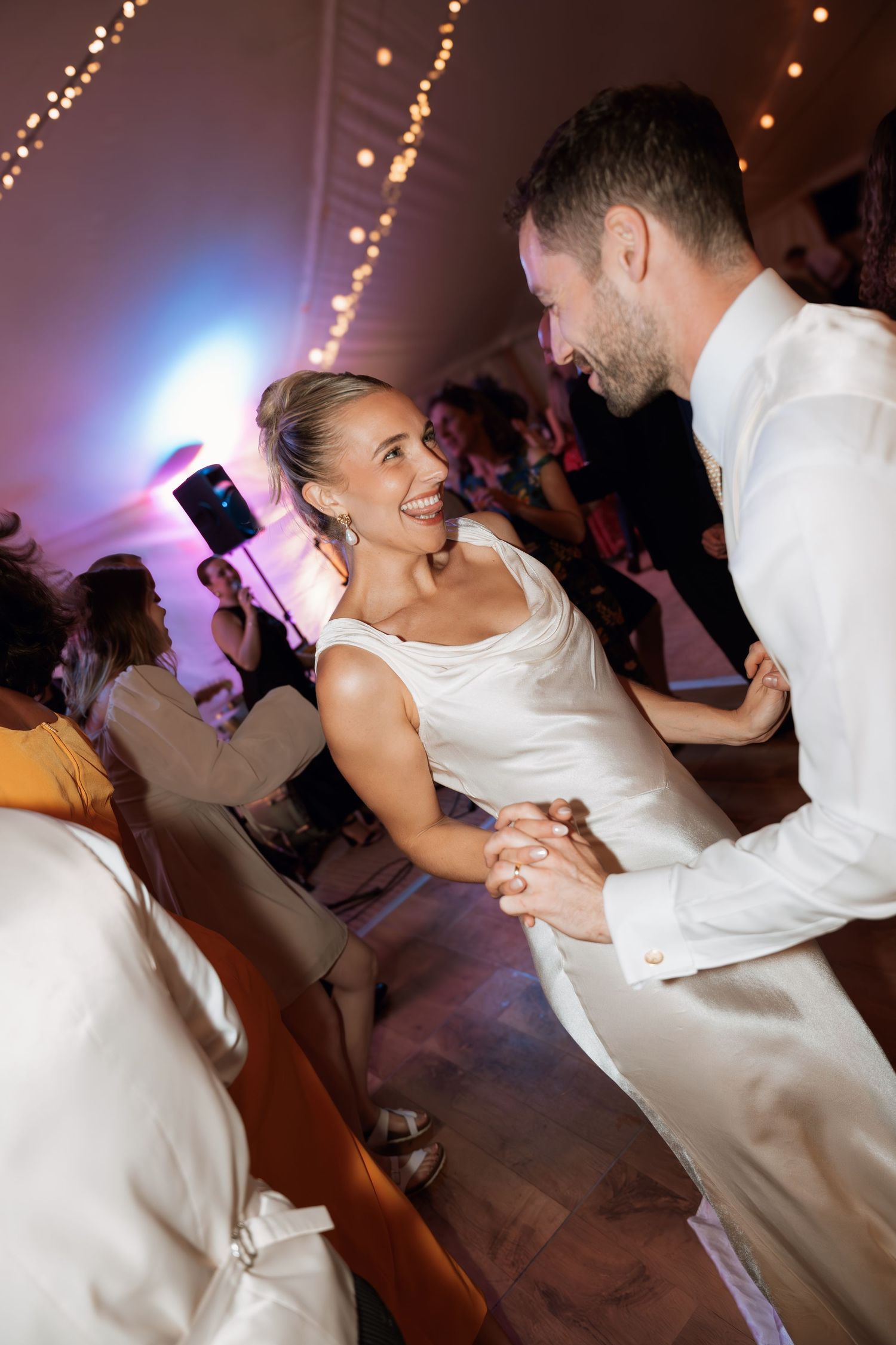 Energetic dance floor moment captured between two people during a wedding celebration.