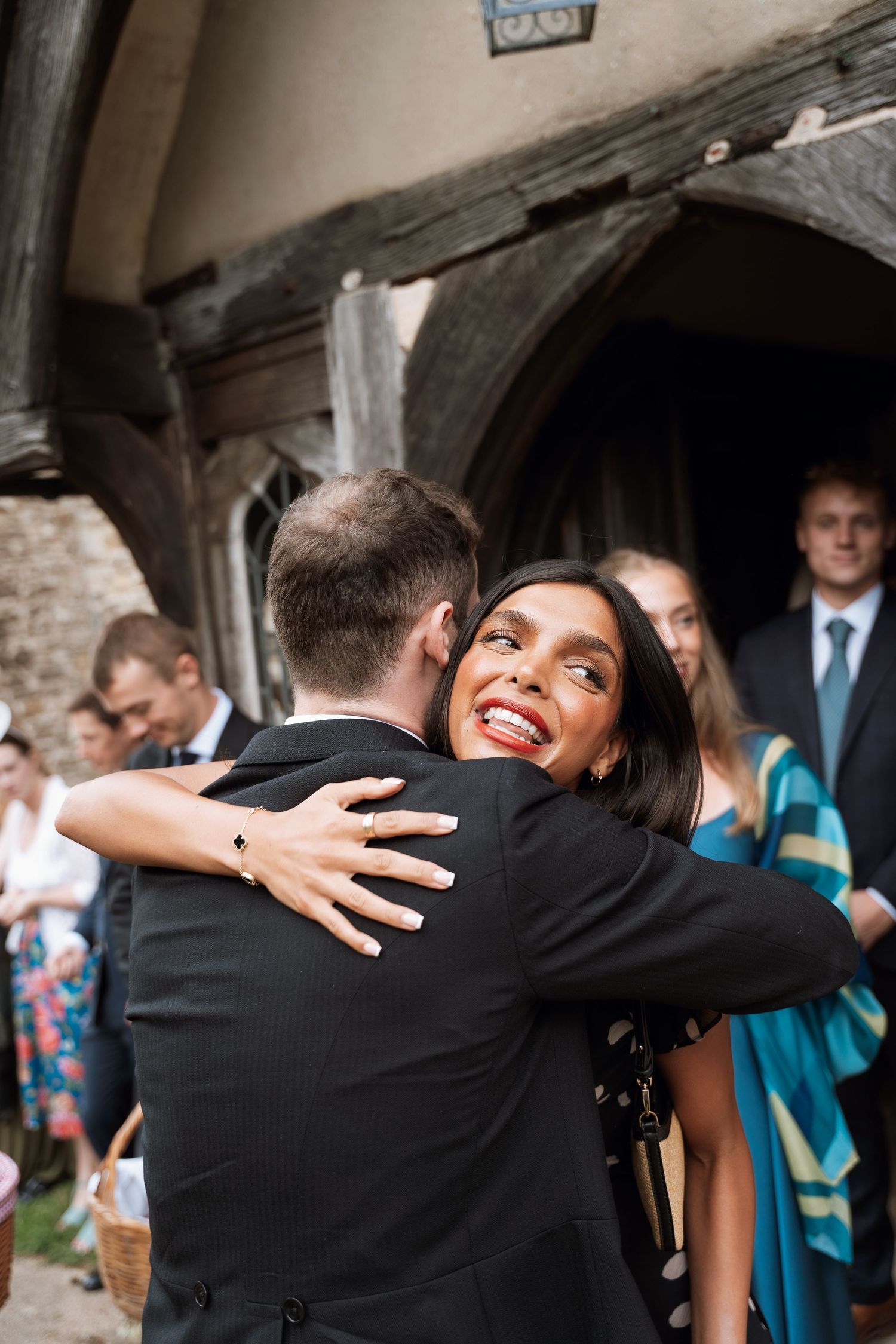 Wedding guests share warm embraces and hugs during a joyful reception celebration.