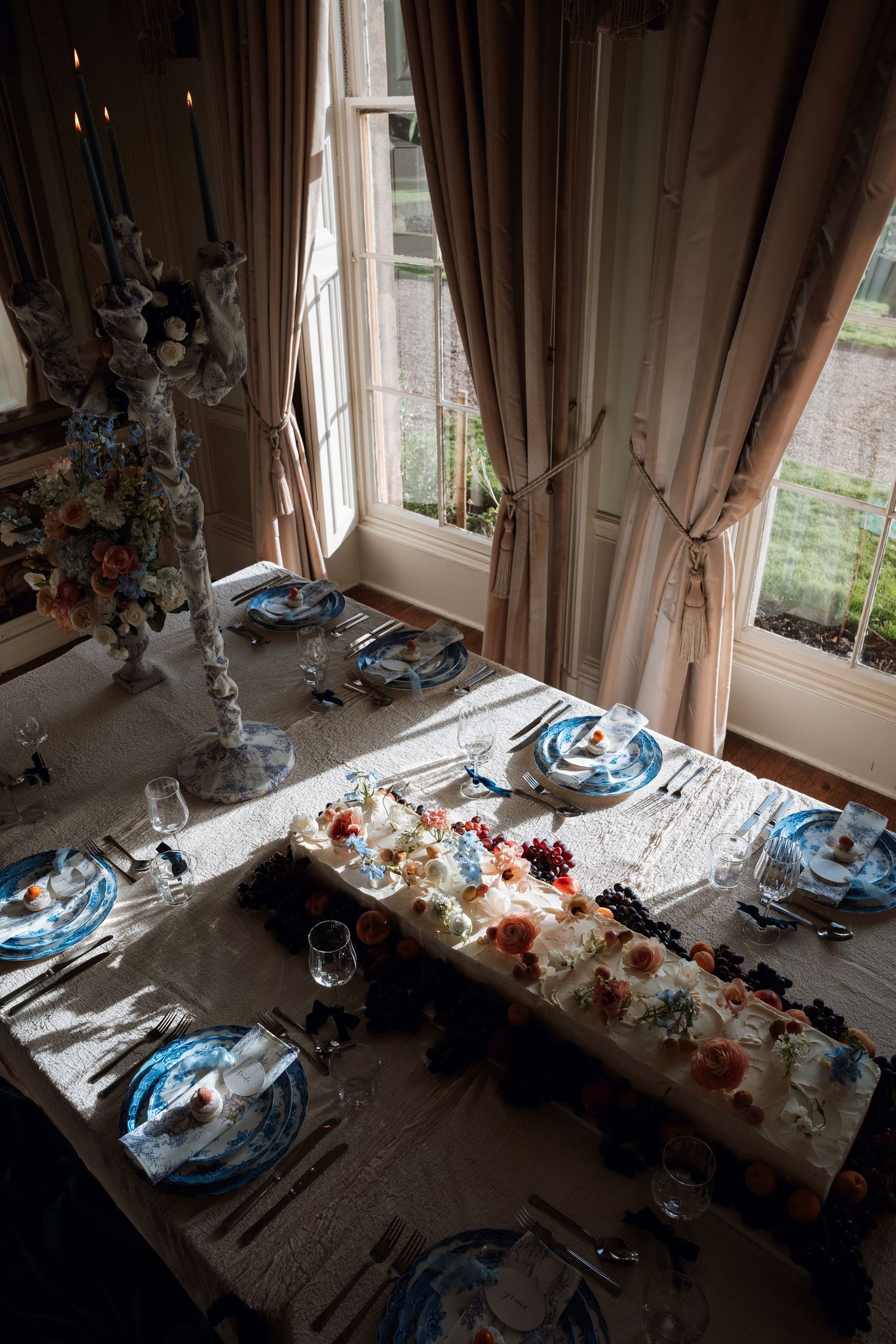 Wedding reception table with blue place settings and scattered decor after a celebration.