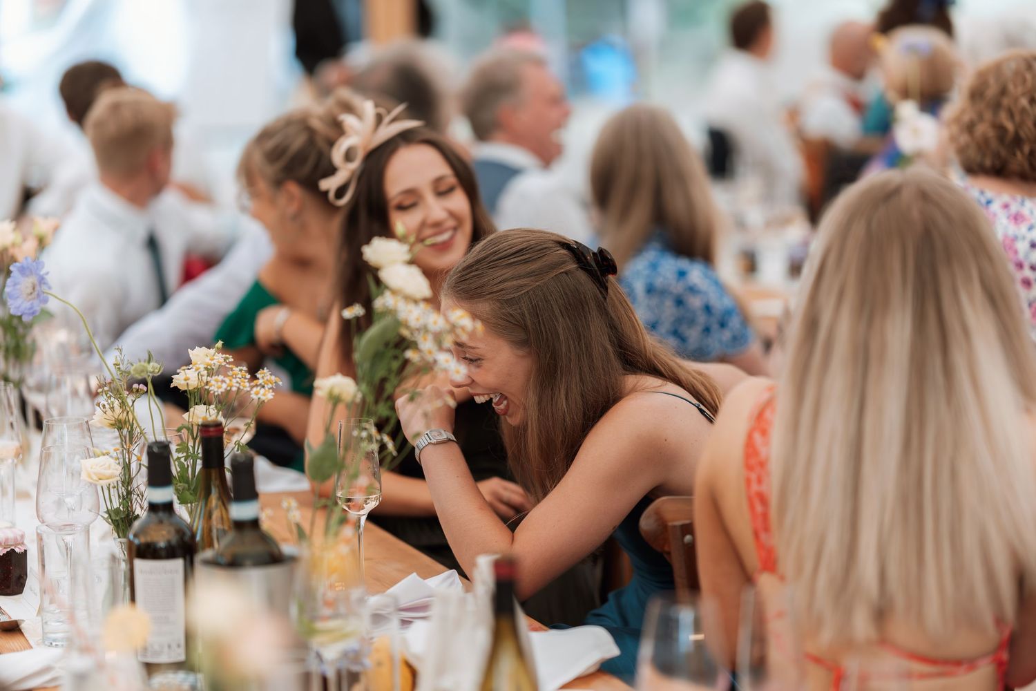 Wedding guests share laughs and conversations at an elegant reception dinner table.