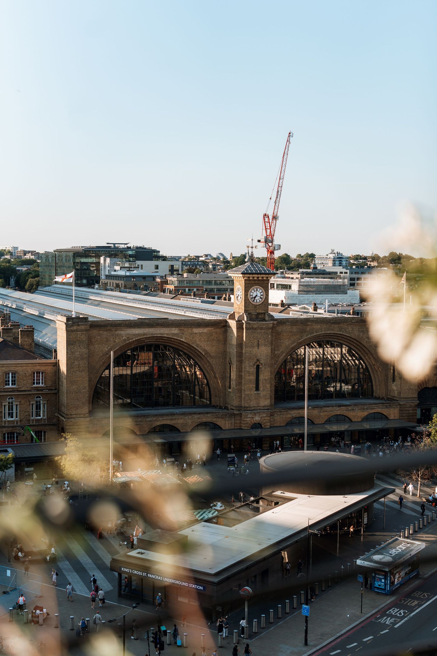Panoramic view of a stone bridge architecture with industrial cranes visible in the urban skyline.