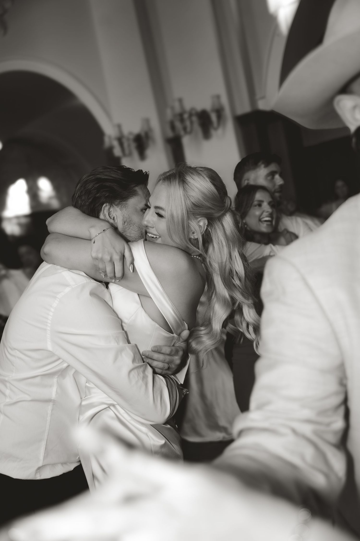 A couple share an intimate dance moment at their wedding reception in black and white photography.