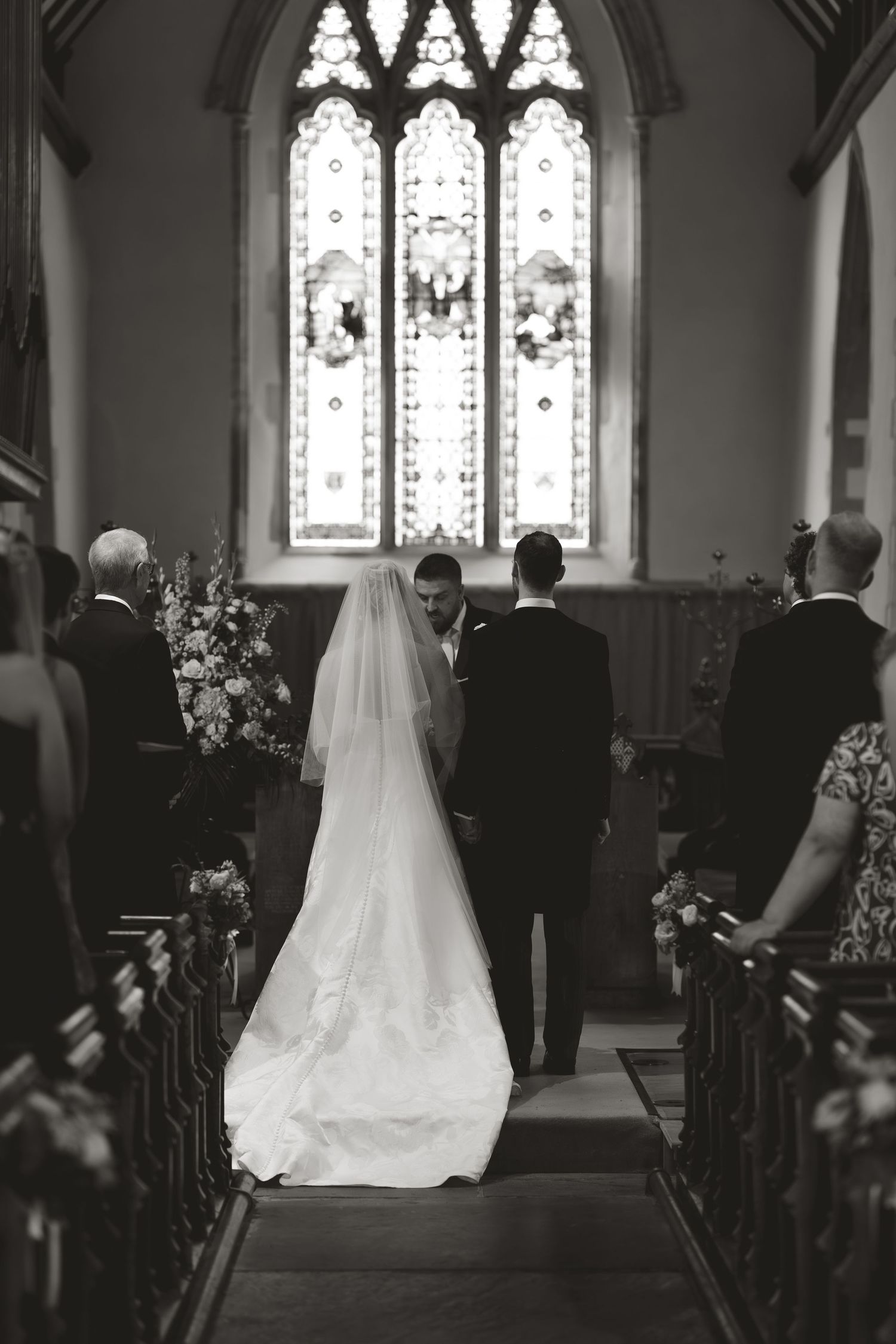 A black and white photo of a traditional church wedding ceremony with stunning Gothic architecture.