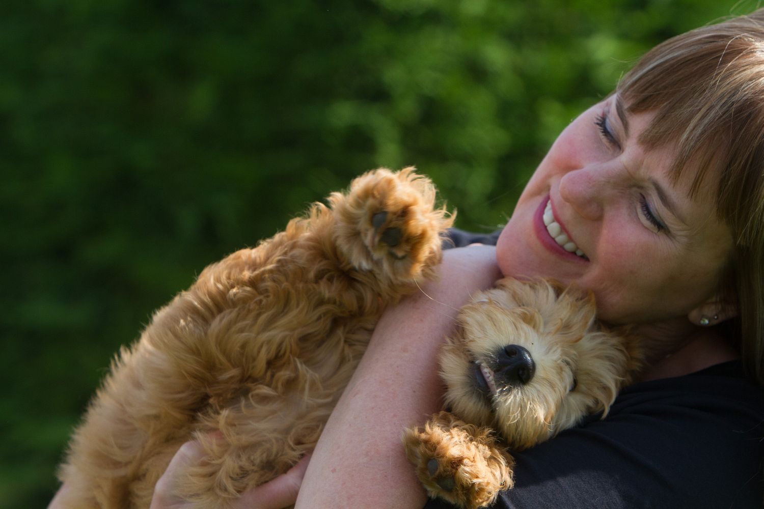 woman and golden doodle puppy very happy smiles