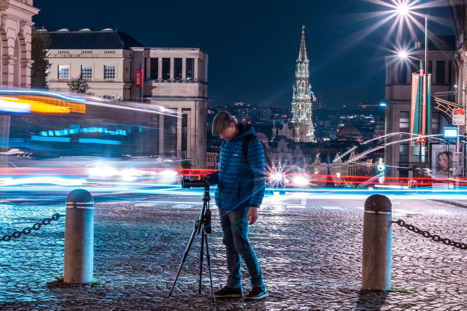 Jason Kravitz in Brussels long exposure photo with car trails and grand place in background. Photo by Fredography.