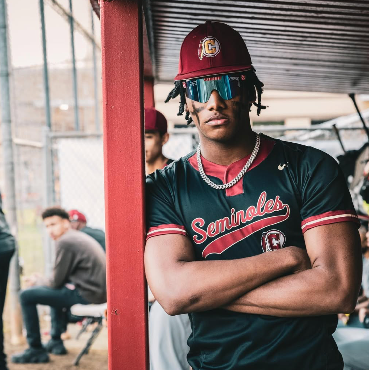Baseball player in Seminoles uniform poses with sunglasses and helmet.