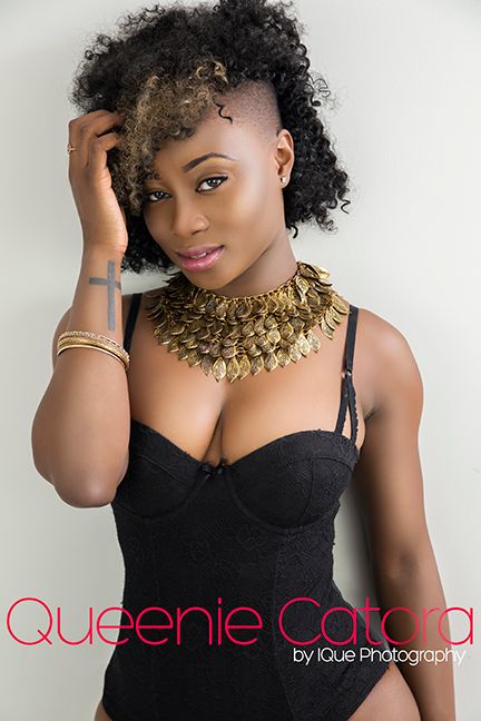 Portrait featuring statement gold necklace and black corset top with styled curly hair.