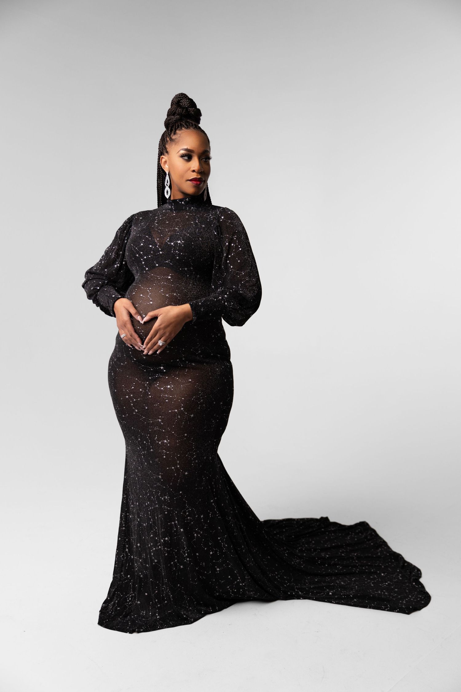 Elegant formal portrait in black sparkly mermaid gown against neutral background.