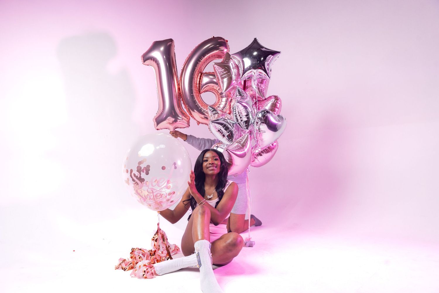 Sweet sixteen celebration photo with pink balloons and number decorations.