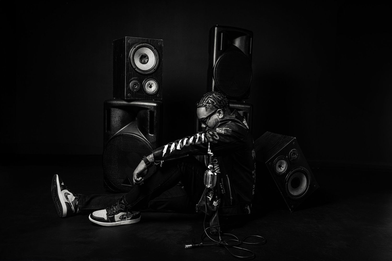 Black and white photo of music equipment setup with studio monitors and DJ gear.