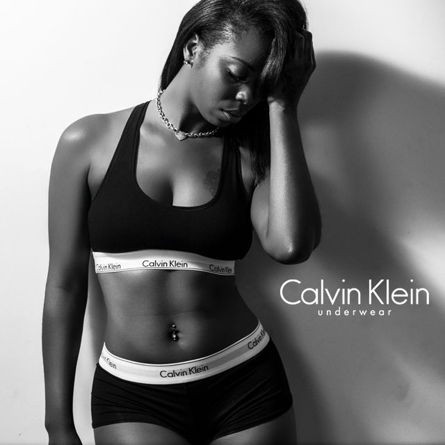 Black and white Calvin Klein underwear advertisement with dramatic lighting and shadows.